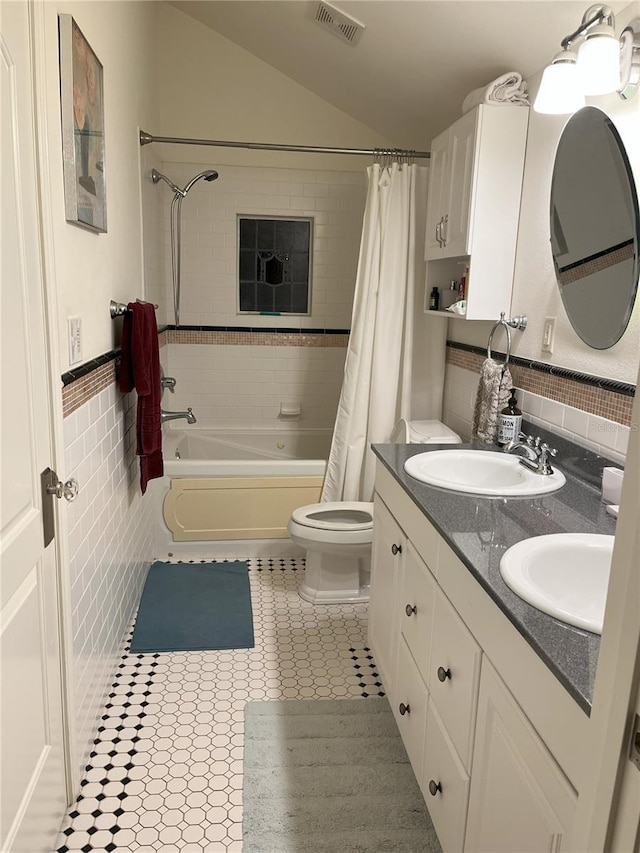 bathroom with visible vents, a sink, tile walls, and tile patterned floors