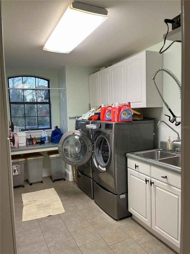 laundry area featuring cabinet space, washer and clothes dryer, and light tile patterned floors