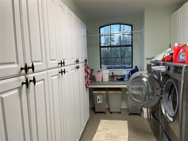 laundry room featuring cabinet space, washing machine and clothes dryer, and tile patterned floors