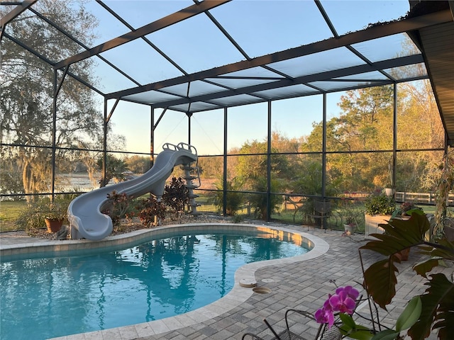 pool featuring a water slide, a patio area, and a lanai