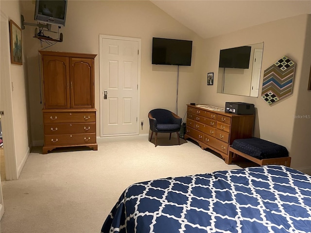 bedroom with lofted ceiling, light carpet, and baseboards