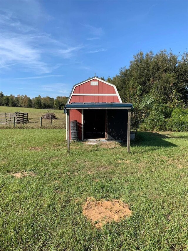 view of outdoor structure with fence, an outdoor structure, and a rural view