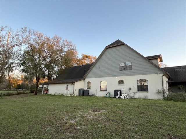 rear view of property with a yard and central AC unit