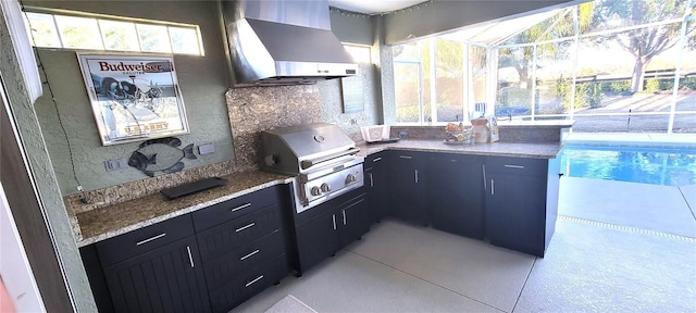 kitchen with light stone countertops and wall chimney exhaust hood