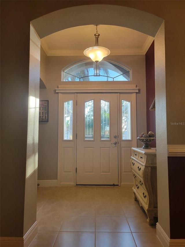 foyer featuring crown molding and light tile patterned floors