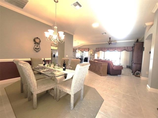 dining room with lofted ceiling, crown molding, ceiling fan with notable chandelier, and light tile patterned flooring