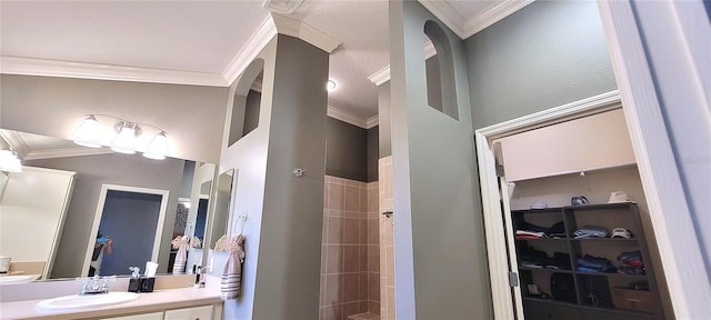 bathroom with vanity, ornamental molding, and a shower