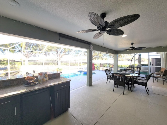 view of patio with ceiling fan and glass enclosure