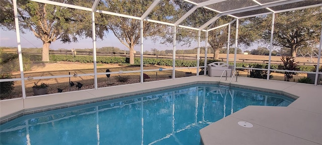 pool with a rural view, a patio, and glass enclosure
