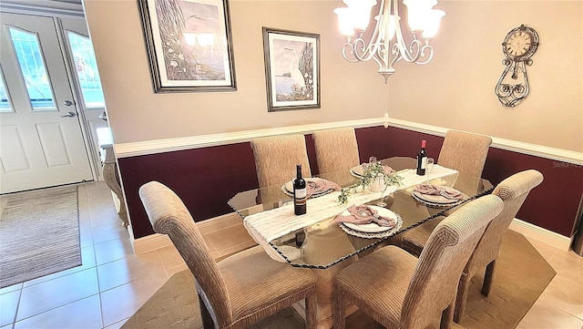 dining area featuring a chandelier, tile patterned flooring, and baseboards