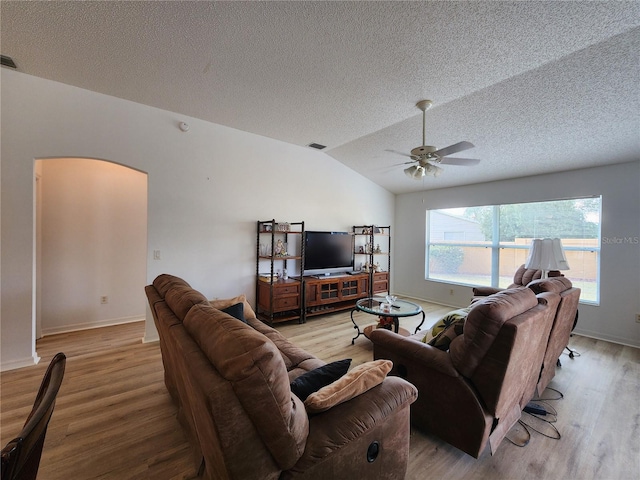 living room featuring vaulted ceiling, a textured ceiling, ceiling fan, and light hardwood / wood-style floors