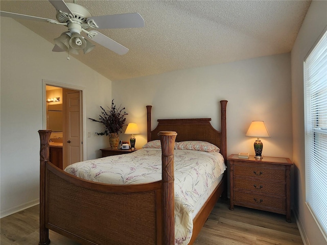 bedroom featuring ceiling fan, light hardwood / wood-style flooring, a textured ceiling, and vaulted ceiling