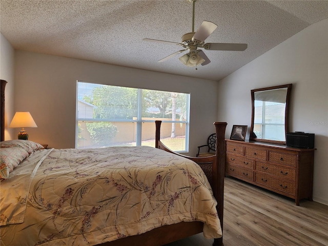 bedroom featuring multiple windows, lofted ceiling, and light hardwood / wood-style flooring