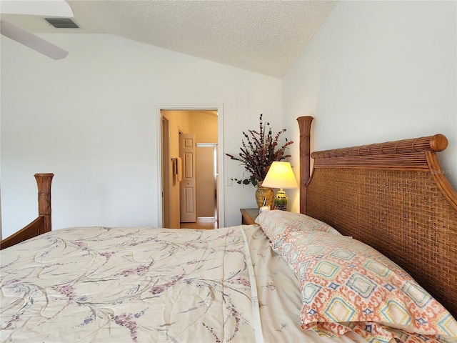 bedroom featuring lofted ceiling and a textured ceiling