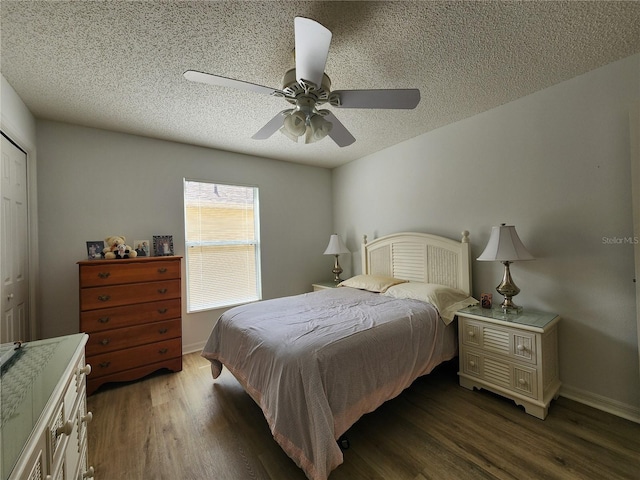 bedroom featuring dark wood-type flooring, ceiling fan, and a textured ceiling