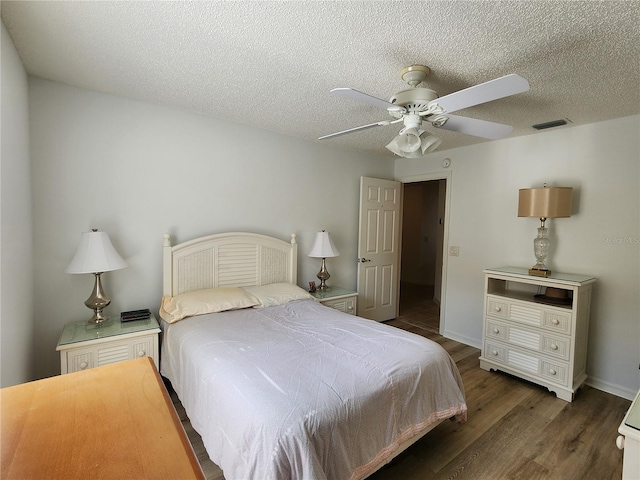 bedroom with ceiling fan, a textured ceiling, and dark hardwood / wood-style flooring