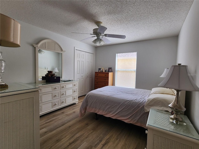 bedroom with ceiling fan, dark hardwood / wood-style flooring, a closet, and a textured ceiling