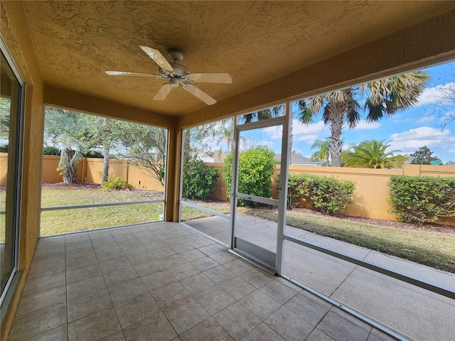 unfurnished sunroom with ceiling fan