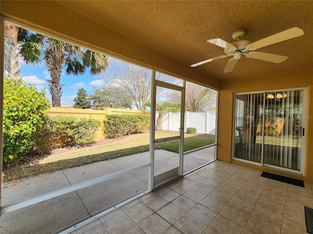 unfurnished sunroom with ceiling fan