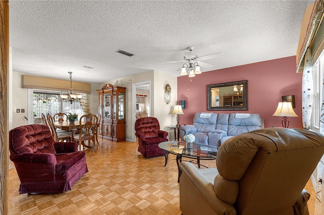 living room featuring a textured ceiling, ceiling fan with notable chandelier, and light parquet floors