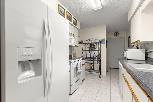 kitchen with white cabinetry, sink, light tile patterned floors, white appliances, and a textured ceiling