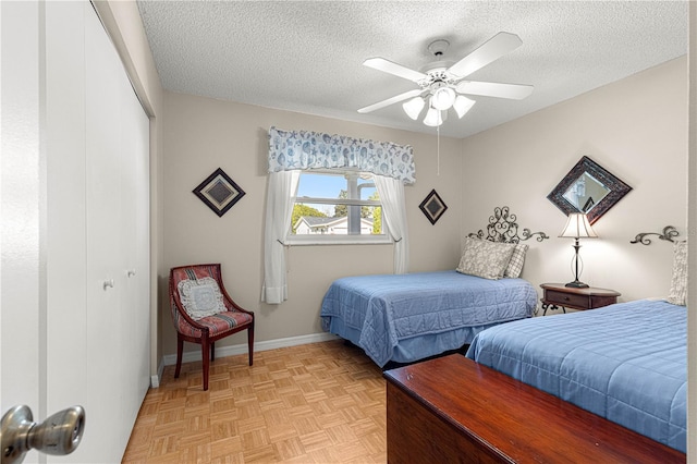 bedroom with light parquet flooring, ceiling fan, a textured ceiling, and a closet