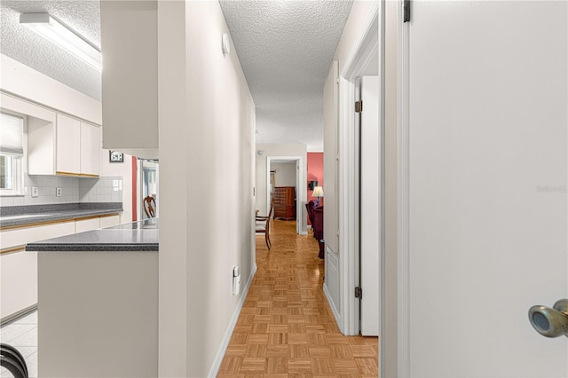 hallway featuring a textured ceiling and light parquet floors