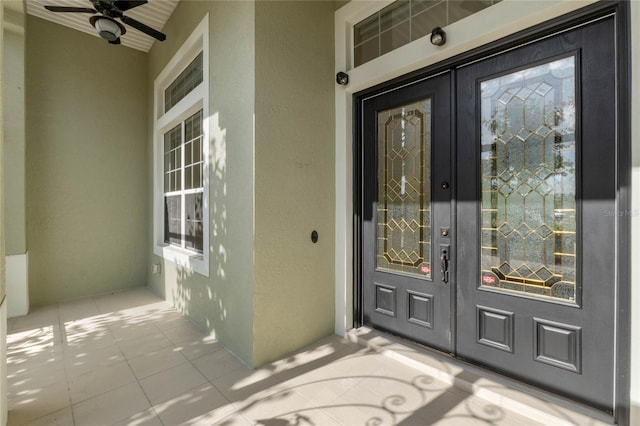 view of exterior entry featuring french doors and ceiling fan