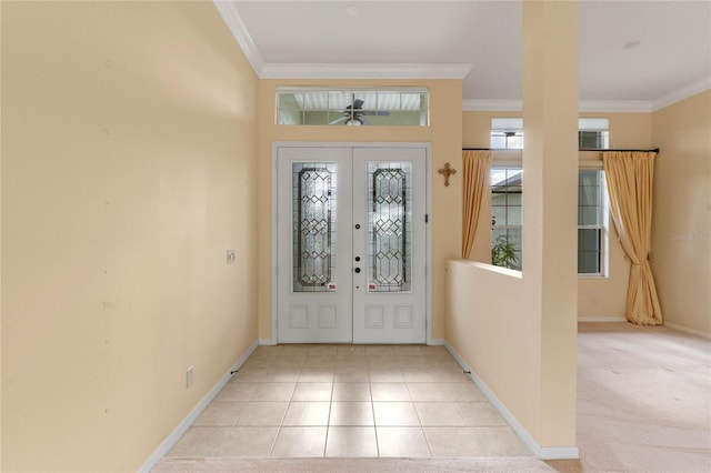 tiled foyer with crown molding and french doors