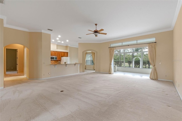 unfurnished living room featuring light carpet, crown molding, and ceiling fan