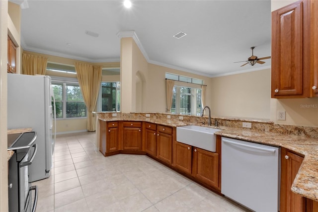 kitchen featuring dishwashing machine, light stone countertops, white fridge, sink, and kitchen peninsula