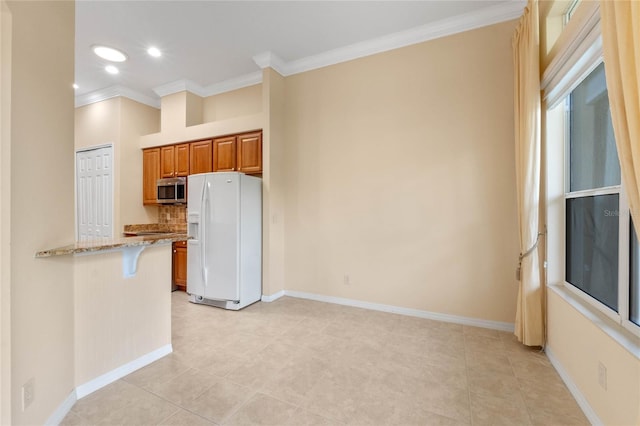 kitchen with white refrigerator with ice dispenser, a breakfast bar, crown molding, kitchen peninsula, and light stone countertops