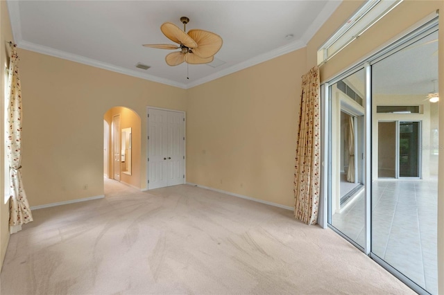 spare room with crown molding, ceiling fan, and light colored carpet