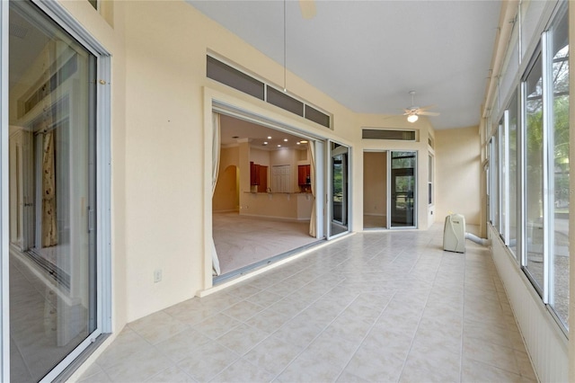 unfurnished sunroom with ceiling fan