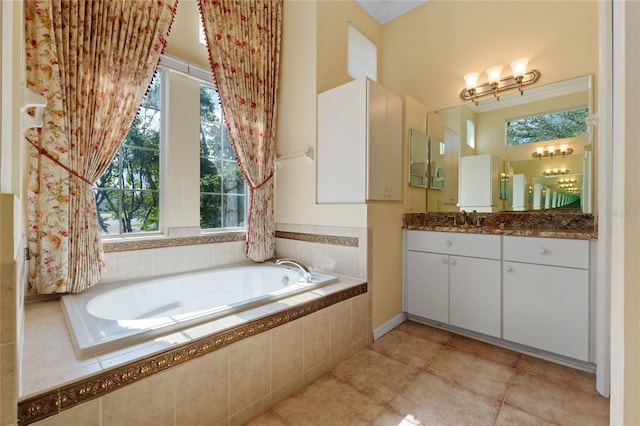 bathroom featuring tile patterned floors, vanity, and tiled tub