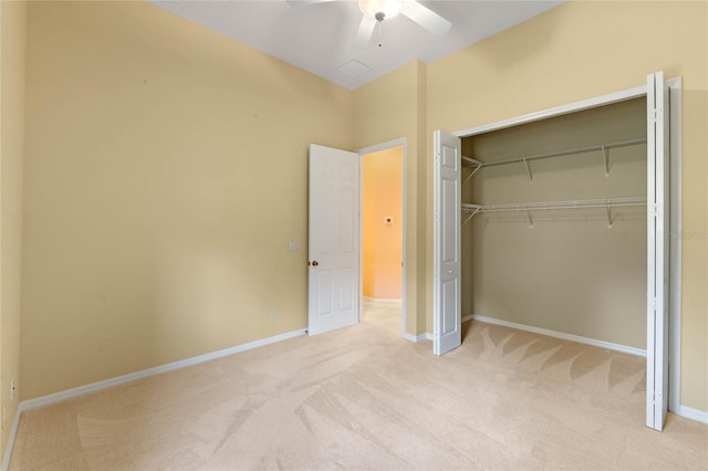 unfurnished bedroom featuring ceiling fan, a closet, and light colored carpet