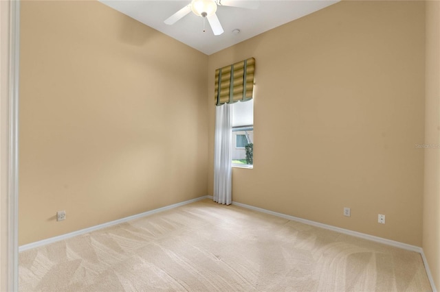 spare room featuring light colored carpet and ceiling fan