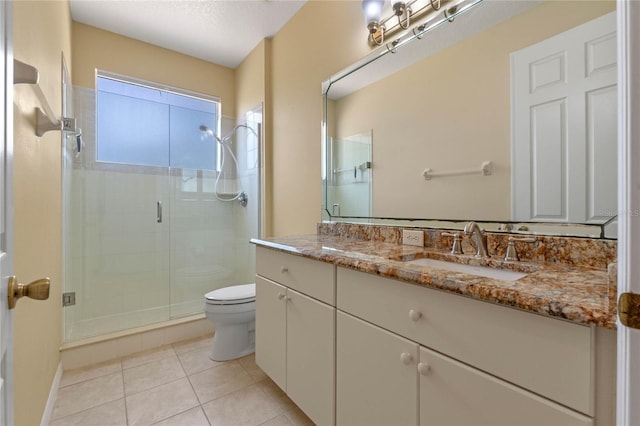 bathroom featuring tile patterned flooring, vanity, toilet, and walk in shower