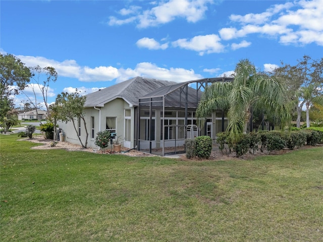 rear view of house with a yard and a lanai