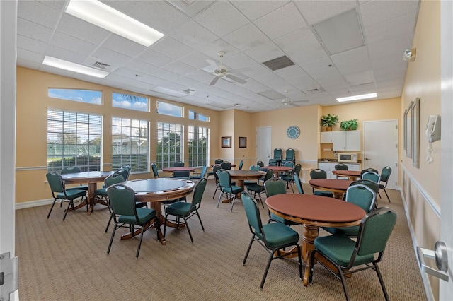 dining area featuring ceiling fan, a paneled ceiling, and light colored carpet