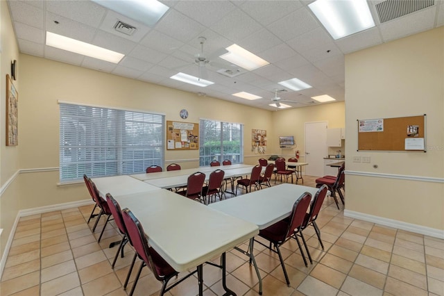 tiled dining room with ceiling fan and a paneled ceiling