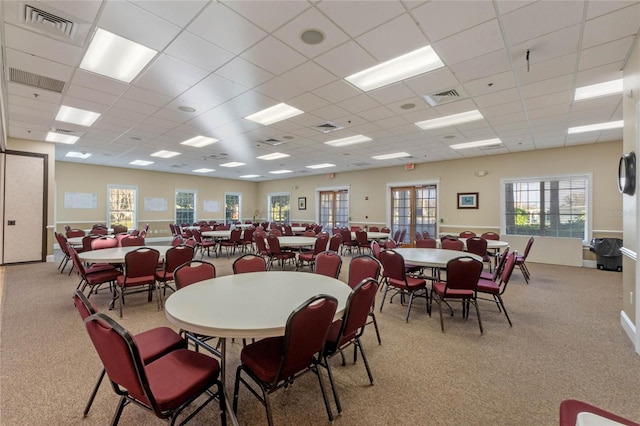 carpeted dining room featuring a paneled ceiling