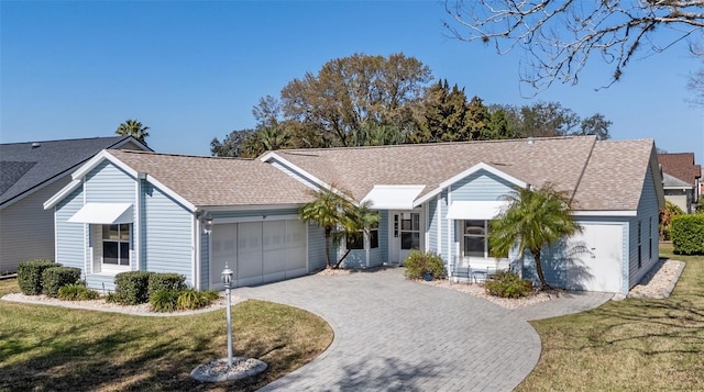 single story home featuring a garage and a front lawn