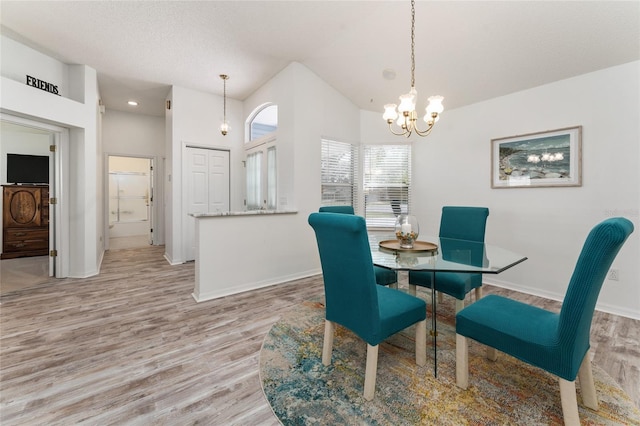 dining area with lofted ceiling, an inviting chandelier, and light wood-type flooring