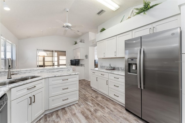 kitchen featuring white cabinetry, vaulted ceiling, sink, and stainless steel fridge with ice dispenser