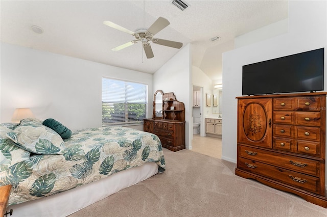 carpeted bedroom featuring ceiling fan, lofted ceiling, connected bathroom, and a textured ceiling