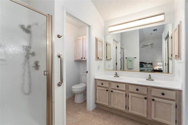 bathroom featuring a shower with shower door, vanity, toilet, tile patterned floors, and a textured ceiling