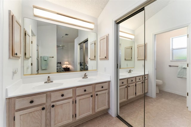 bathroom featuring vanity, toilet, tile patterned flooring, and a textured ceiling