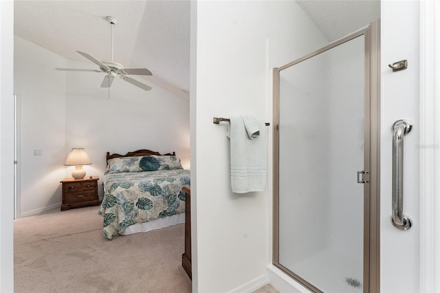 bathroom featuring lofted ceiling, ceiling fan, a shower with door, and a textured ceiling