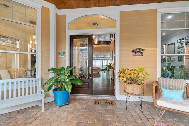 entrance to property featuring covered porch and visible vents